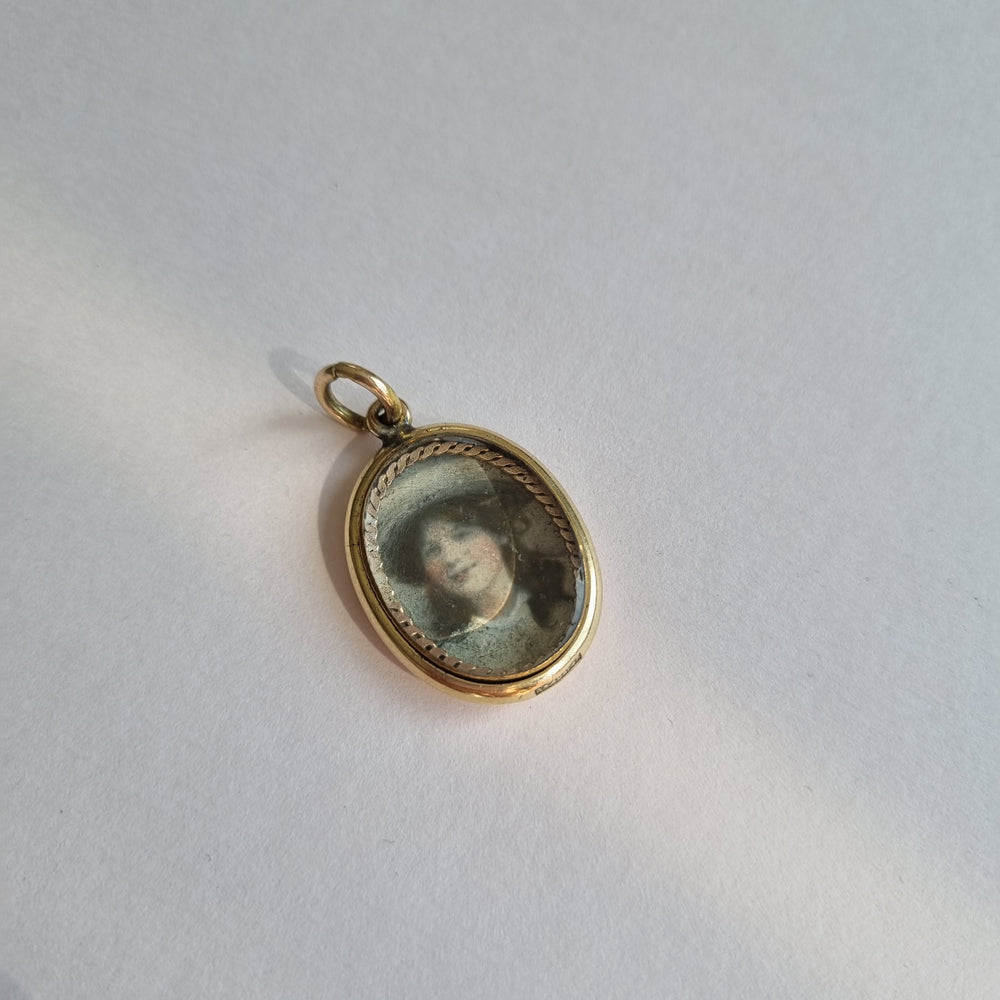 Antique oval portrait locket with blue enamel and set with pearls and garnet in 9kt gold